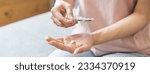 Small photo of Sick ill asian young woman, girl hand taking tablet pill capsule out from blister pack, painkiller medicine from stomach pain, head ache, pain for treatment, take drug or vitamin at home, health care.