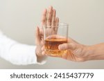 Alcoholism, hand of refuse alcoholic beverage, drink whiskey while person holding glass give to her. Treatment of alcohol addiction, having suffered abuse problem alcoholism isolated on background.