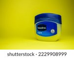Small photo of Vaseline bottle on yellow background with copy space. Skin care product vaseline or petroleum jelly. Afyonkarahisar, Turkey - November 19, 2022.