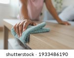 Woman cleaning and wiping the table with microfiber cloth in the living room. Woman doing chores at home. Housekeeping concept.
