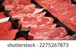 Small photo of Red rib eye meat for sale in meat department in a shop. Raw fresh meat ribeye for steak perfectly arranged in trays.