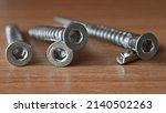 Small photo of hex bolt screw by hex wrench, the bolts lie on the table in the workshop. hex screws for furniture assembly. macro, close up.