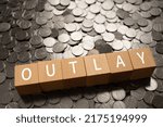 Small photo of Wooden blocks with "OUTLAY" text of concept and coins.