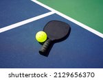 Small photo of Pickleball Paddle and pickle ball of court.