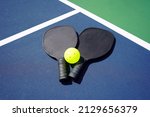 Small photo of Pickleball Paddle and pickle ball of court.