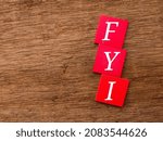 Small photo of Selective focus.Colored wooden cube with word FYI on wooden background.