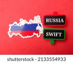 Top view Russia flag and wooden board with text RUSSIA SWIFT on red background.