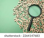 Wooden word and magnifying glass on a green background. Business concept.