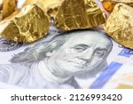 Small photo of Precious metals and currency investment concept : Gold colored iron ore on a US dollar money, depicting investing in gold market to diversify risk through the use of futures contract and derivatives.