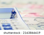 Small photo of Tax exemption for persons with disabilities, disabled people concept : Man with physical impairment sit in a wheelchair near a white tax button on a calculator, depicts tax deduction for disabled guy.
