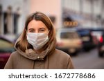 Woman wearing face mask during coronavirus outbreak. Virus spread flu prevention carantine. Girl in a facemask on a streets of Italy