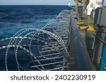 Small photo of View of the vessel hardening on board ships using razor wire and spikes, to stop pirates from boarding the ship. These ship protection measures are employed when the ship passes high risk areas