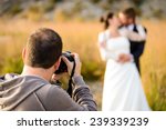 Wedding photographer taking photographs of groom and bride