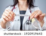 Small photo of Close up isolated image of a caucasian doctor holding a tape measure in her hands showing 102 centimeters as abdominal circumference upper limit in healthy people. Concept for weigh loss and fitness.
