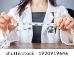 Small photo of Close up isolated image of a caucasian doctor holding a tape measure in her hands which shows 40 inches as abdominal circumference upper limit in healthy people. Concept for weigh loss and fitness.