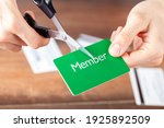 Small photo of Close up isolated image of A young woman cutting a membership card. Customizable with copy space on the card. Suitable for cutting the costs, cancellation, termination of subscription and membership