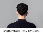 Young man from back with curly taper fade haircut.