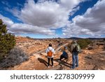 Family relaxing on hiking trail. Friends standing on top of the mountain. Potash Road or the Lower Colorado Scenic Byway, Moab, Utah,USA