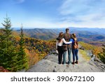 Family hiking in autumn mountains enjoying beautiful mountain view. People on hiking trip in Blue Ridge Mountains. North Carolina, USA.