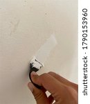 Small photo of White Wall putty epoxy calk on cream color concrete wall after it was glazed by Asian male hand in Thailand, under do it by yourself, DIY, concept for industrial and home renovation work or project