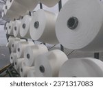 Small photo of Large bobbin of light thread inTextile Mills Sut girni. Textile threads industry. Yarn weave traditional textile fabric manufacturing for clothing