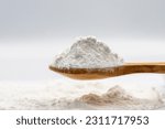 Powdered sugar on wooden spoon. Powdered sugar or icing sugar isolated on white background