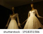 Stylish wedding dresses on mannequins. Mannequins in luxury wedding dresses, dark background. Wedding fashion exhibition.