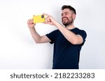 Young caucasian man wearing black T-shirt over white background taking a selfie to post it on social media or having a video call with friends.