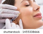 Small photo of Anti-aging face treatment. Close up side on portrait of young smiling pretty woman relaxing on rejuvenation procedure of cheek bone zone by specialist
