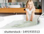 Small photo of Yappy little girl dipping hands in the water stock photo