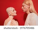 Small photo of Albino man with long blonde hair posing nearby bald unladylike female