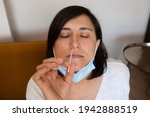 Portrait of relaxed young woman taking a Self-swabbing home tests for COVID-19 at home with Antigen kit. Introducing nasal stick to check the infection of Coronavirus. Quarantine, pandemic.