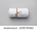 Rolled white towel tied with a...