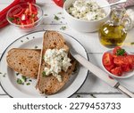 Small photo of Marinated feta cheese with roasted ry bread, chopped tomatoes and bell peppers on white background