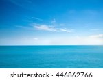 Beautiful white clouds on blue sky over calm sea with sunlight reflection, Bali Indonesia. Tranquil sea harmony of calm water surface. Sunny sky and calm blue ocean. Vibrant sea with clouds on horizon