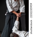 Small photo of Disarm a knife armed opponent. Senior black belt aikido masters during a training session.