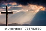 Jesus Christ cross. Easter, resurrection concept. Christian wooden cross on a background with dramatic lighting, colorful mountain sunset, dark clouds and sky, sunbeams 