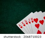 Small photo of Royal straight flush poker cards on a green felt table background