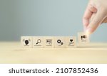 Small photo of Customer journey concept. Customer behavior anlysis for business and marketing plan for target customer. Hand holds the wooden cube with customer journey process icon on grey background and copy space