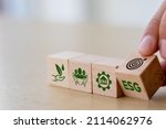 Small photo of ESG concept of environmental, social and governance. Sustainable corporation development. Hand flips wooden cubes with target setting to ESG icon with other ESG icons on bright background.Copy space.