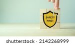 Small photo of Safety first symbols, work safety, caution work hazards, danger surveillance, zero accident concept. Wooden cubes with smart grey background. Employees safety awareness at workplace. Safety banner.