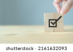 Small photo of Corporate regulatory and compliance. Goals achievement and business success. Task completion. Ethical corporate. Do the right thing. Quality and ISO symbol. Placing wooden cube with checkmark icon.