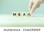 Small photo of Business mergers and acquisitions concept. Share acquisition, asset business acquisition, amalgamation. Business review and development model. The abbreviation M and A on smart background, copy space.