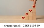 Small photo of Customer engagement, increasing customer loyalty concept. Building relationships, increase brand awareness, and drive sales. Wooden cube blocks with red hearts and customer loyalty icon on background.