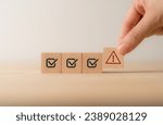 Small photo of Problem and error warning concept. Wooden cubes with triangle caution warning sign, warning system for notification error and maintenance. Incident, risk, contingency management. Proactive approach.