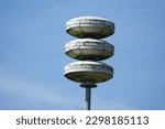 Small photo of Close up of pole with Dutch acoustic air alarm system also known as air raid siren alert aka luchtalarm in Dutch with cloudy sky in Holland used to warn public for example during war or attack