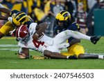 Small photo of Alabama quarterback Jalen Milroe #4 is brought down by Michigan defensive back Makari Paige #7 and defensive back Will Johnson #2 during the 2024 Rose Bowl game Monday, Jan. 1, 2024, in Pasadena.
