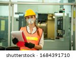 Small photo of Female Mechanic wearing protective mask to Protect Against Covid-19,Female technician worker working and checking machine in a large industrial factory,Coronavirus has turned into a global emergency