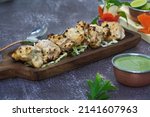 Small photo of Chicken malai tikka is a popular kebab and kabab made by using boneless chicken pieces in a creamy cashew nuts based marination. Malai kabab is a creamy kebab with a distinct flavour of green cardamom