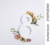 Small photo of Number 8 with fresh spring flowers with green leaves on bright white background. Minimal Women's day, March 8th or birthday concept. Flat lay, top view.